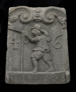 Facade stone from gate with musketeer and ribbon with text vive orange 46, facing stone sculpture sculpture building component