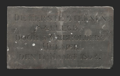 Facade stone with text THE FIRST STONE LOCATED BY THE BROTHERS HELMER DEN 17E MARCH 1862, facing brick first stone building part
