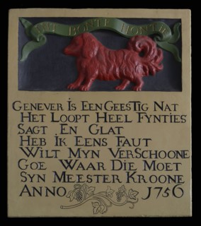 Facade stone with bas-relief dog with text ribbon: INT BONTE DOG and text below, gable sculpture sculpture material building