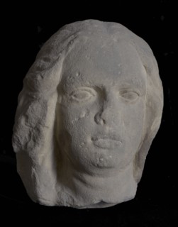 Female head with wavy hair, sculpture sculpture sandstone stone, sculpted Woman's head with wavy hair flattened to the left