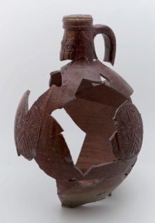 Fragments of stoneware Bartmann jug, also called Bellarmine jug, dark brown, on stand, beardmug tableware holder soil find
