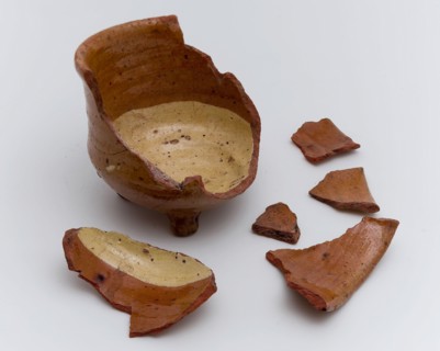 Fragments earthenware cooking jug, completely lacquered in yellow and brown, on three legs, cooking jug