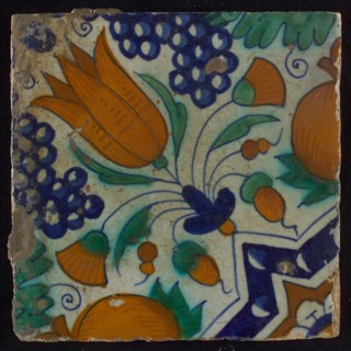 Tile, blue, green, orange and brown on white, star tulip with quarter rosette, bunches of grapes and orange-apples, wall tile