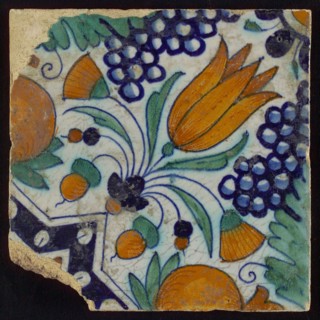 Tile, blue, green, orange and brown on white, star tulip with quarter rosette, bunches of grapes and orange-apples, wall tile