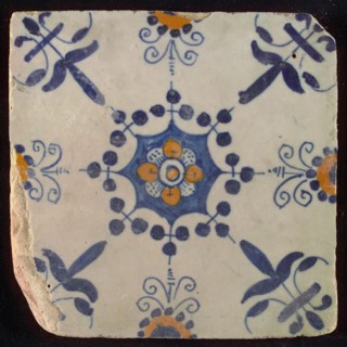 Tile, blue draft and orange on white, central flower within star shape, three-spot around, half rosette, corner motif lily, wall