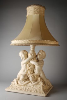 Simon Miedema, White table lamp, with decorated plaster foot of two putti and lampshade trimmed with lace, table lamp lamp