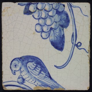 Blue tile with bird in left side view, sitting on branch with grape between the paw, grape bunch and tendril of pilaster with 39