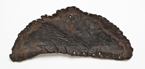 Heel piece of leather shoe with sewing holes along the edges, shoe footwear clothing soil finding leather, archeology