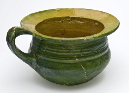 Green chamber pot with curved bottom, standing ear and wide flat edge, yellow and green glaze, pot holder sanitary soil found