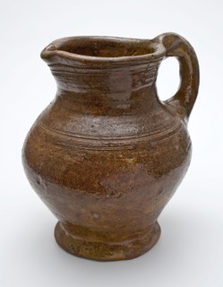 Red pottery jug with convex belly, ear and shank, rings around the neck, jug holder soil find ceramic earthenware glaze lead