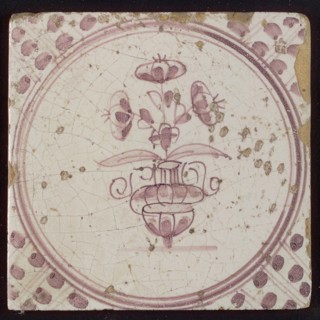 White tile with purple small flowerpot in circle frame with meanders, wall tile tile sculpture ceramic earthenware glaze, baked