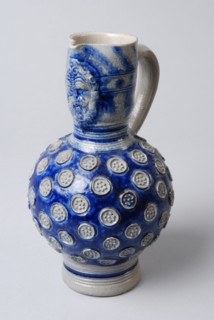 Stoneware jug with ear, belly with imposed rosettes, neck with mask, jug crockery holder ceramic stoneware glaze salt glaze