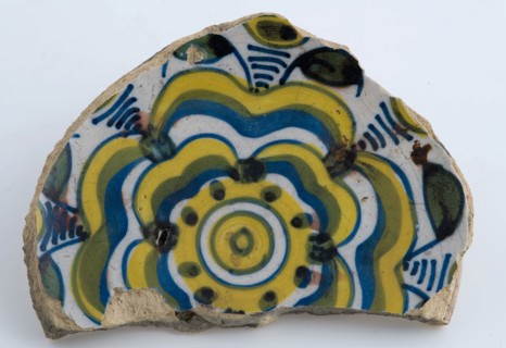 Mirror fragment of majolica dish with yellow and blue stylized flower decoration, plate dish crockery holder soil find ceramic