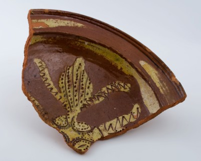 Fragment of earthenware dish on stand lobes, yellow silt decoration and sgraffitet, dish plate crockery holder soil find
