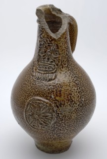 Brown speckled Bartmann jug, also called Bellarmine jug, under the simple beard mask medallion with rosette, Bartmann jug