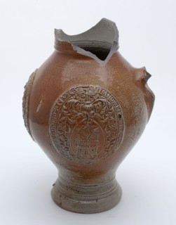 D.E., Stoneware jug round three medallions with borders and coat of arms, slim model, signed, jug crockery holder soil find