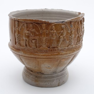 Fragment of stoneware farmer's pitch with dance pairs and text under arcades, farmer's pitcher crockery holder fragment soil