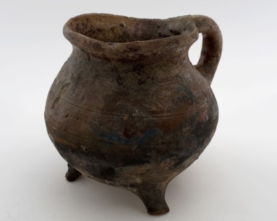 Pottery cooking jug, grape-model, red shard with sparing lead glaze, sausage ear, on three legs, cooking jug