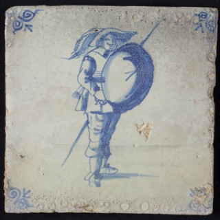 White tile with blue warrior with lance and shield; corner pattern ox head, wall tile tile sculpture ceramic earthenware glaze