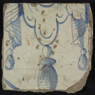 Tile of chimney pilaster, blue on white, bottom of pleated lap with three hanging tassels, chimney pilaster tile pilaster
