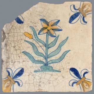 Tile, flower on ground in yellow, brown, green and blue on white, corner pattern french lily, corner point yellow, wall tile