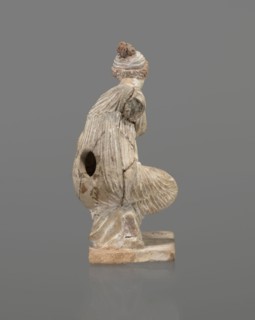 Terracotta figurine of a girl throwing dice. Figurine of a crouching girl throwing dice: weight of