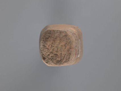 Pyramidal clay seal with a roughly square stamp surface and rounded corners. Shallow incisions at