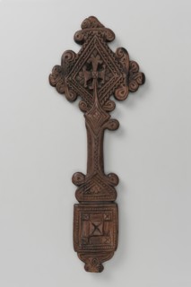 Hand cross. The arms of the cross are rhombus-shaped, the tops decorated with volutes topped with