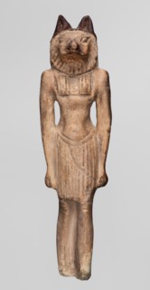 Amulet — Anubis. Anubis is depicted as a striding man with the head of a dog Canidae. Arms hang at