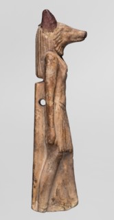 Amulet — Anubis. Anubis is depicted as a striding man with the head of a dog Canidae. Arms hang at