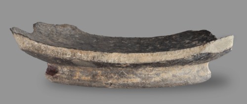 Fragment of a bucchero nero bowl. Bucchero nero, ancient Etruscan vessel fragment with a flat bowl