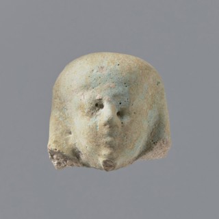 Fragment of a shabti. Fragmentary head of a shabti figurine with indistinct facial features, in a