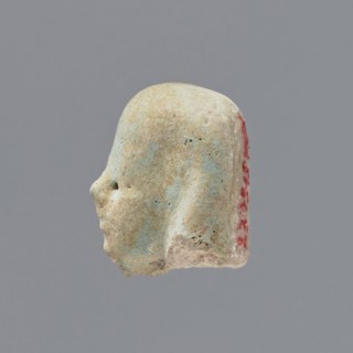 Fragment of a shabti;, Head of a shabti figurine with indistinct facial features, in a smooth wig.