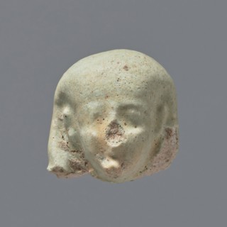 Fragment of a shabti. Head of a shabti figurine with not very carefully rendered facial features,