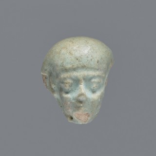 Fragment of a shabti; mummy-shaped funerary figurine. Head of a shabti figurine with carefully