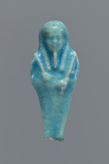 Shabti, mummy-shaped figurine, funerary gift. Back supported by a pillar/pilaster. Legs missing up