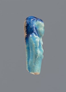 Shabti, Mummy-shaped figurine, funerary gift; back supported by a pillar/pilaster. Legs missing.