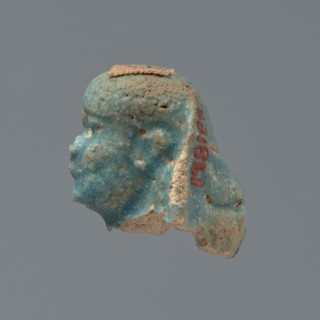 Shabti head, Mummy-shaped figurine head depicting a king. Oval face with full cheeks; prominent