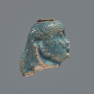 Shabti head, Mummy-shaped figurine head depicting a king. Oval face with full cheeks, prominent