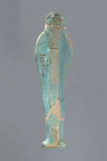Ushabti, Mummy-shaped figurine standing on a base with a flat pillar at the back. Arms folded