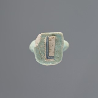 Shabti, Mummy-shaped figurine, standing on a base; head missing. A narrow, slightly convex pillar