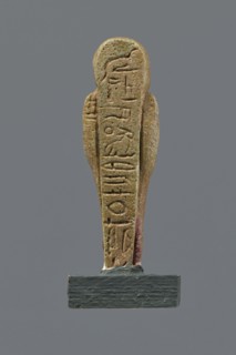 Shabti, mummy-shaped figurine, funerary gift. Mummy-shaped figurine standing on a base, back