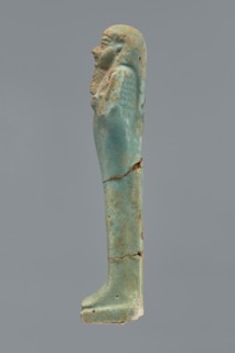 Ushabti, Mummy-shaped figurine shabti. Standing on a base with a flat pillar behind. Arms folded