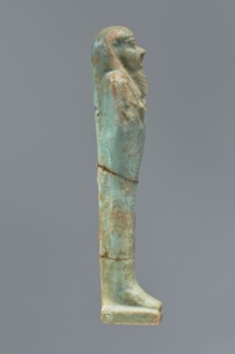 Ushabti, Mummy-shaped figurine shabti. Standing on a base with a flat pillar behind it. Arms folded
