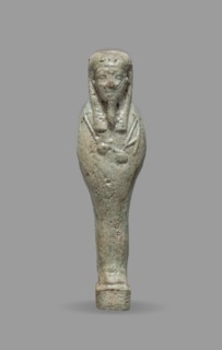 Ushabti, Mummy-shaped funerary figurine standing on a base, back supported by a flat pillar. Arms