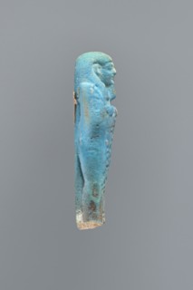 Ushabti, Mummy-shaped figurine, back supported on a flat pillar. Feet missing. Arms crossed on the