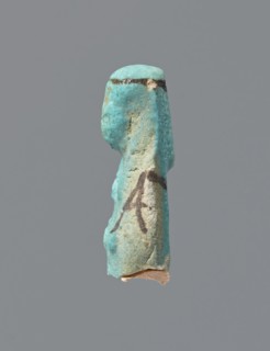 Ushabti, mummy-shaped figurine, preserved head and fragment of torso. Arms crossed on the chest,