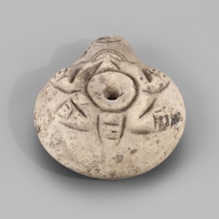 Lamp, Oil lamp with a circular container and a slightly forward burner. Decorated on the top with a