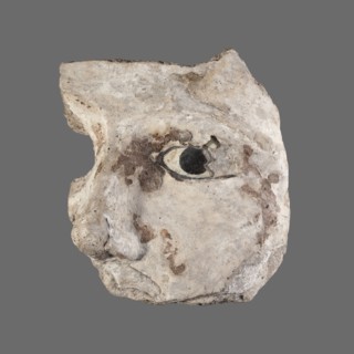 Stucco mask. Fragment of a sarcophagus mask left cheek, nose and left eye inlaid with white and