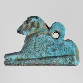 Amulet — ram. Figurine of a ram lying on a flat base, with a loop for hanging on its back. Amulet,